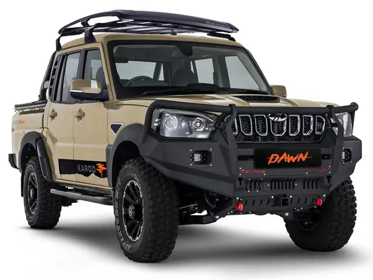 A woman smiling while working on a laptop at a desk.